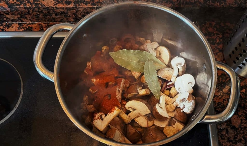 spicing up the goulash with bay leaf, paprika and other spices