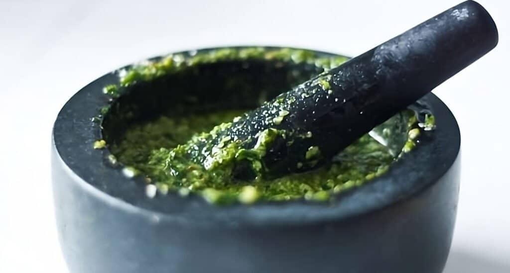 pesto-making in a mortar with pestle