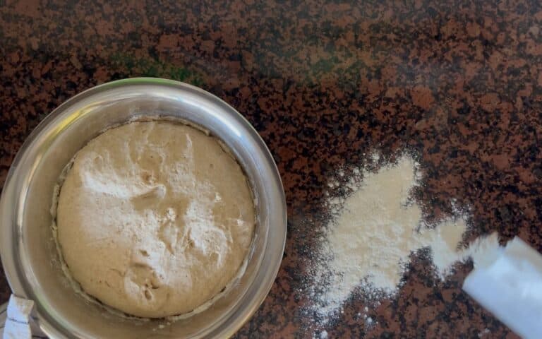 A photo showing the risen döner bread dough in a bowl standing on a working surface covered with some flour