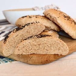 A pile of four döner bread rolls, with one bread cut in half