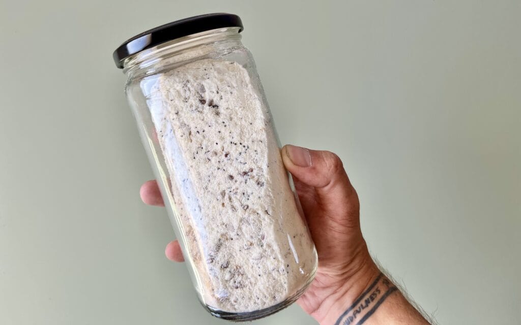 Flour premix with chia and sunflower seeds, stored in a jar.