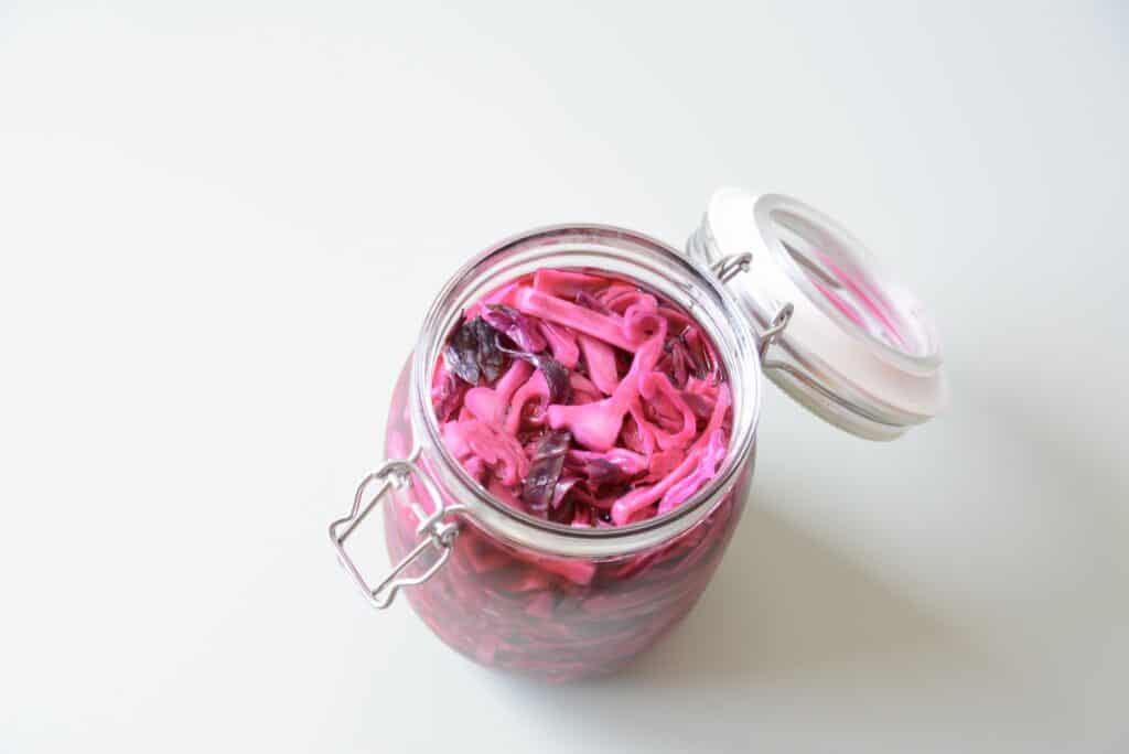 An opened jar containing pickled red cabbage