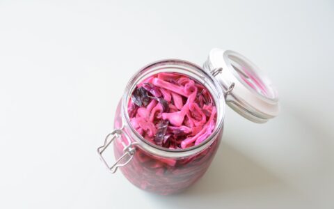 An opened jar containing pickled red cabbage